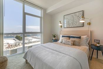 A bedroom with a bed and a large window